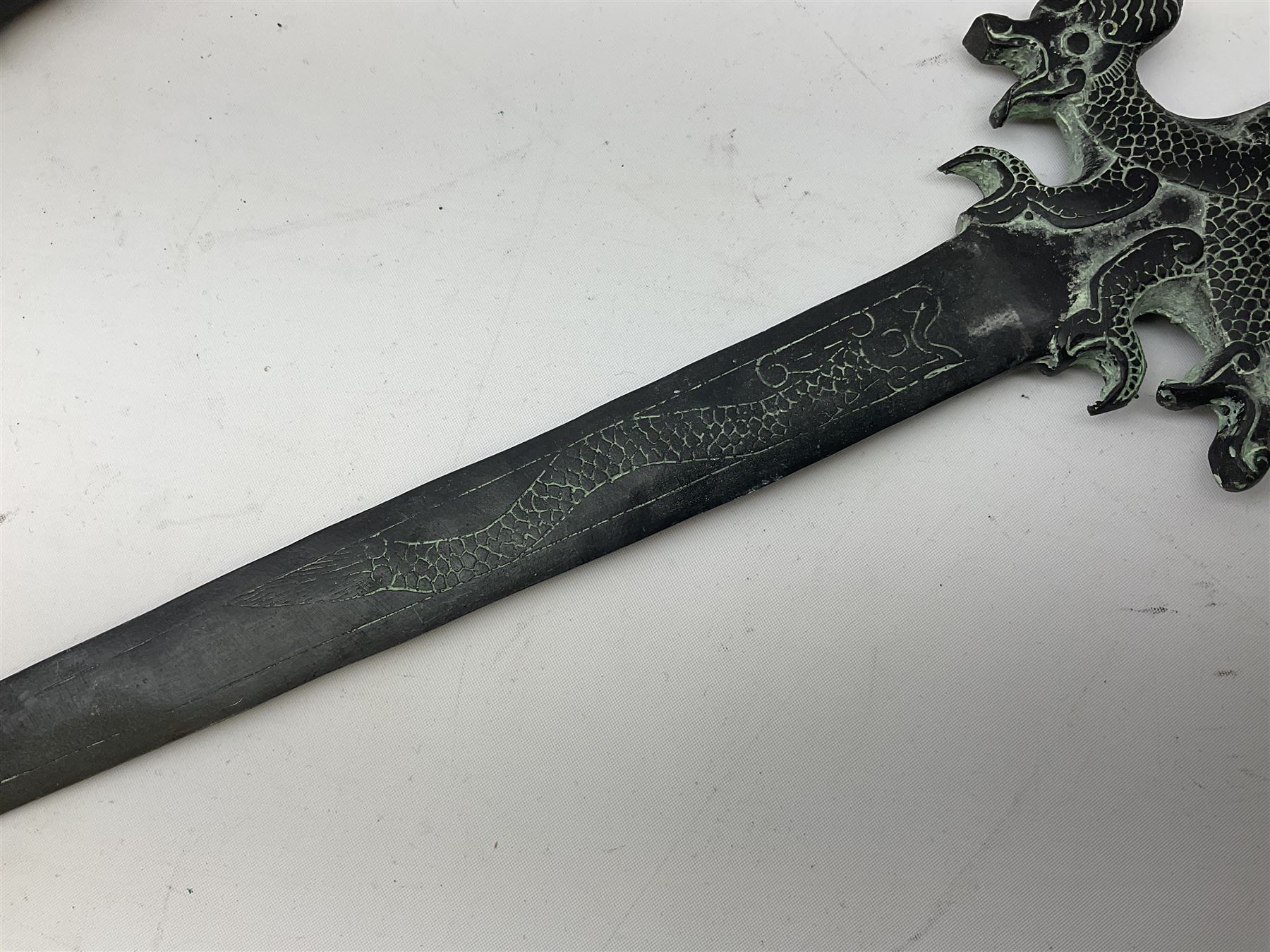 Patinated 'bronze' fantasy dagger, the 26cm blade, hilt and scabbard cast with dragons L50cm overall; hand forged iron spearhead L29.5cm; and a stiletto blade (3)
