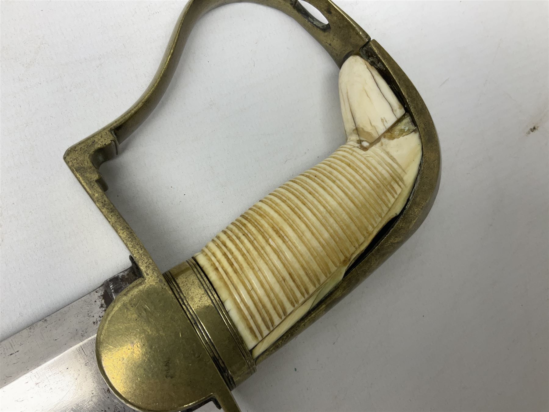 British pattern 1796 Light Cavalry Officer's sword, the 83.5cm curving steel blade marked 'W. Parker London' and 'Warranted' verso, brass stirrup hilt with half-round langets, knucklebow and backstrap with ribbed ivory grip; in brass mounted leather covered scabbard with two suspension rings L97cm overall. This item has been registered for sale under Section 10 of the APHA Ivory Act 
