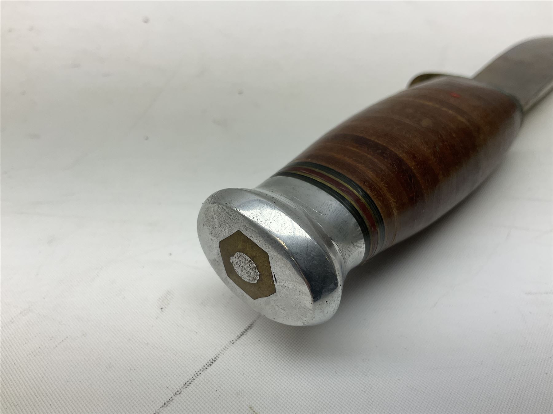 Graduated set of three Bowie knives by J. Nowill & Sons Sheffield England Est. AD1700, each with steel blade, brass cross-piece, stacked leather type grip and alloy pommel; largest blade 13cm and smallest 7.5cm; each in leather sheath (3)