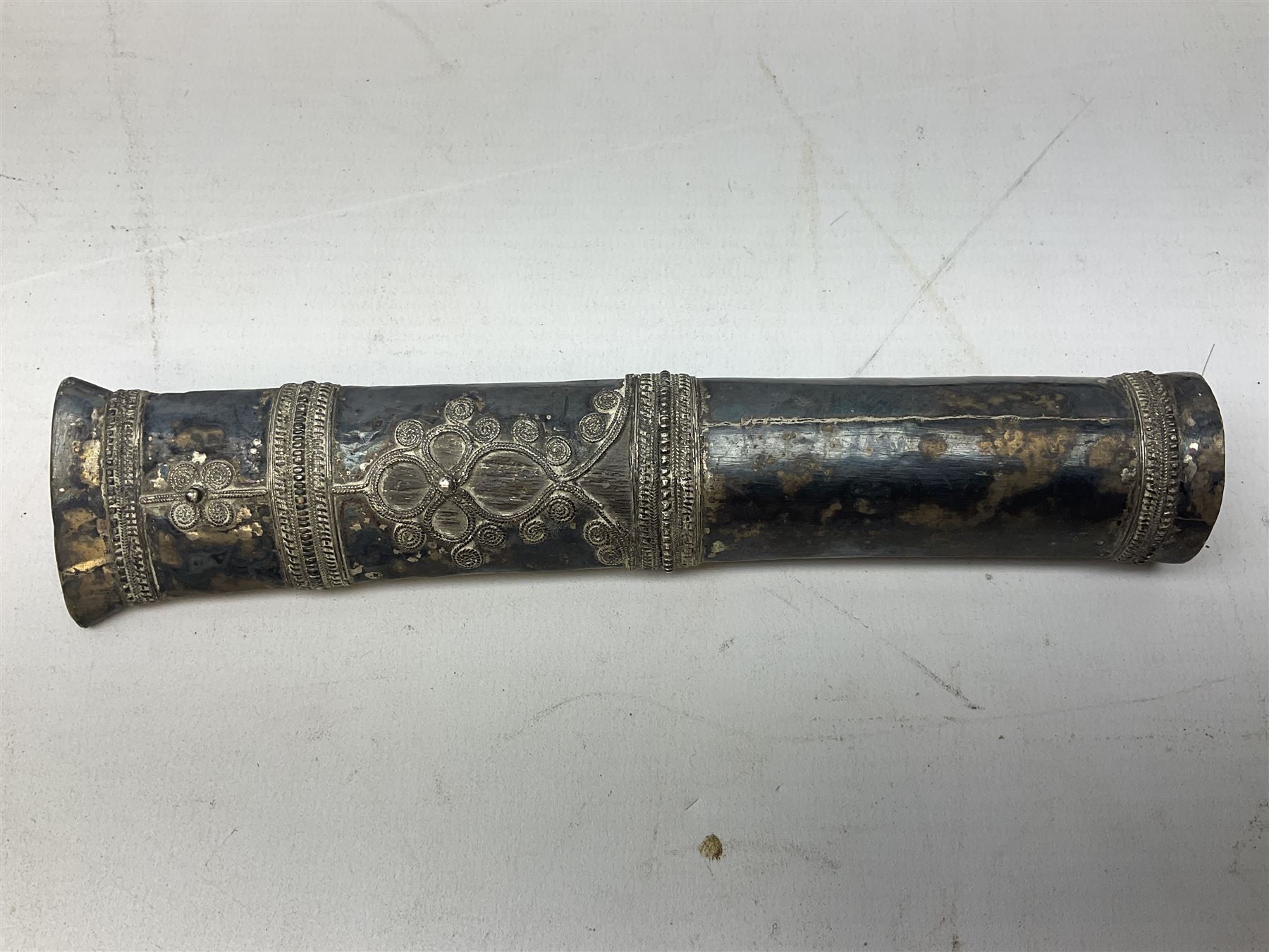 Burmese dha dagger with 15cm steel blade, white metal ferrule and horn handle, in white metal and filigree scabbard L30.5cm; a Burmese long bladed knife with horn handle and brass mounted teak scabbard; and another Eastern dagger in sheath (3)