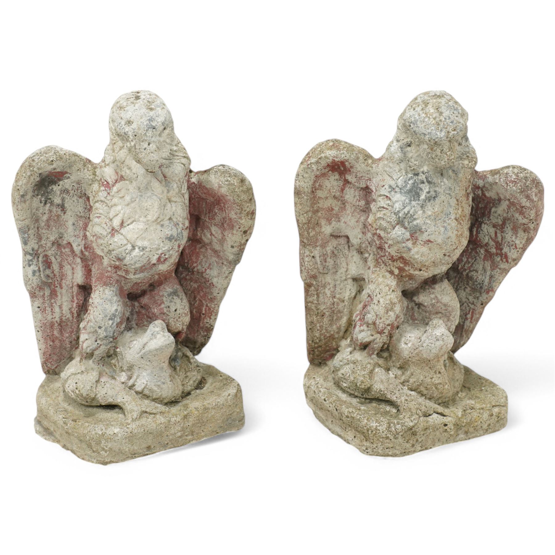 Pair of early 20th century painted stoneware eagle figures, modelled with wings partially spread and talons gripping prey, on a stone plinth