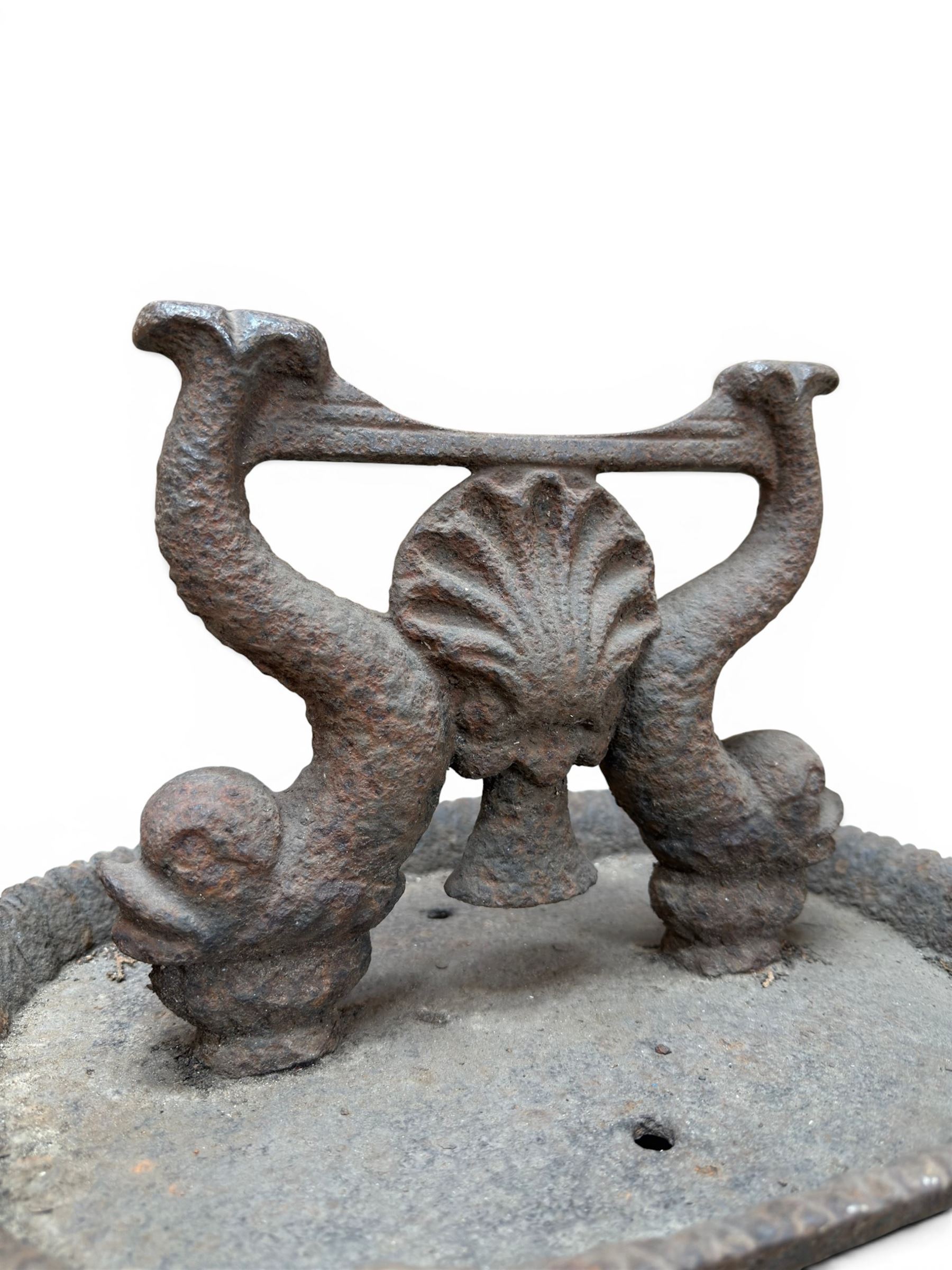 Victorian cast iron boot scraper, supported by two dolphins with central shell motif