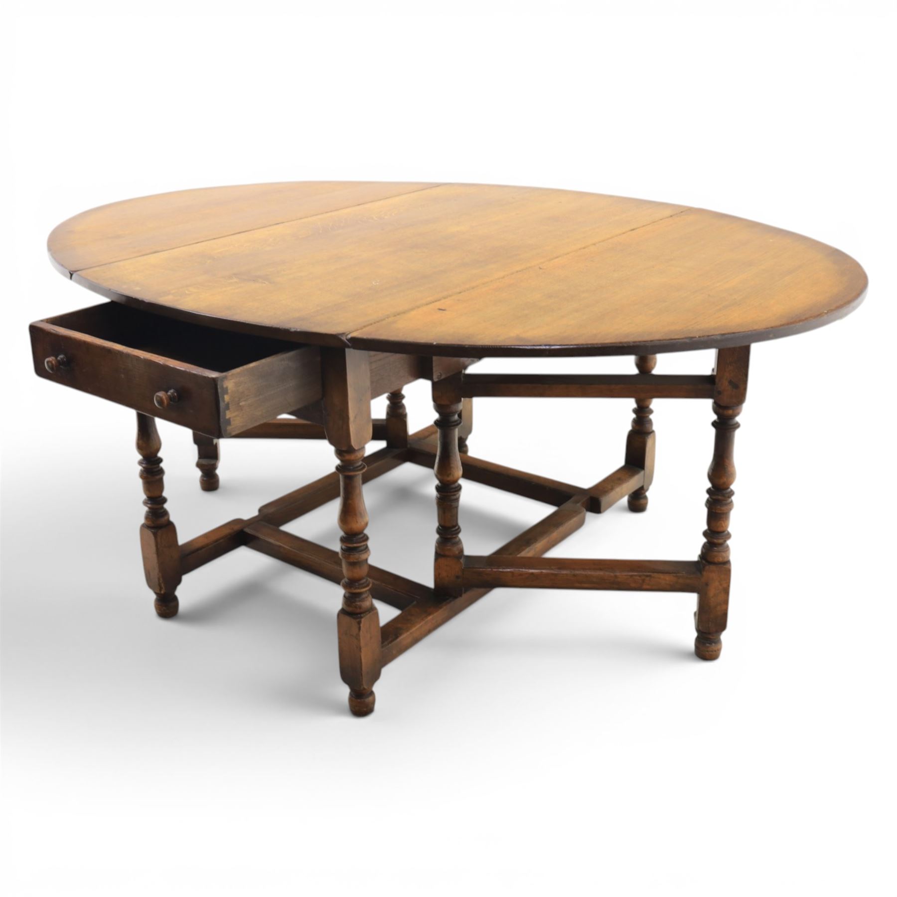 Titchmarsh & Goodwin - 18th century design oak oval drop-leaf dining table with leather dining chairs, the table with drop leaves forming an oval top extending to 180cm, with drawer to either side, raised on turned supports with gateleg, the chairs comprising two carvers in tan leather and two side chairs in green and tan leather backs, brass studded trim with turned uprights and stretchers