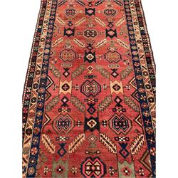Near pair of Persian Azerbaijan red ground runners, each rug decorated with Nazarlik and stylised leaf motifs, enclosed with three band border decorated with flower heads and geometric motifs 

406cm x 99cm 
409cm x 102cm
