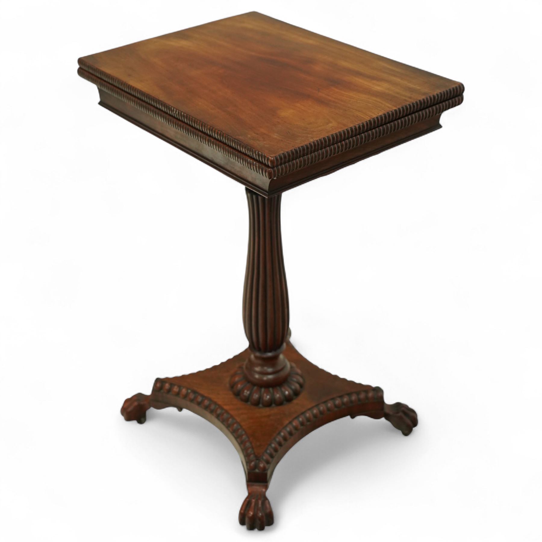 William IV mahogany folding card table of unusually small proportions, rectangular swivel top with gadrooned edge, raised on a slender tapered reeded column over quatreform base with gadrooned border, terminating in carved lion paws feet