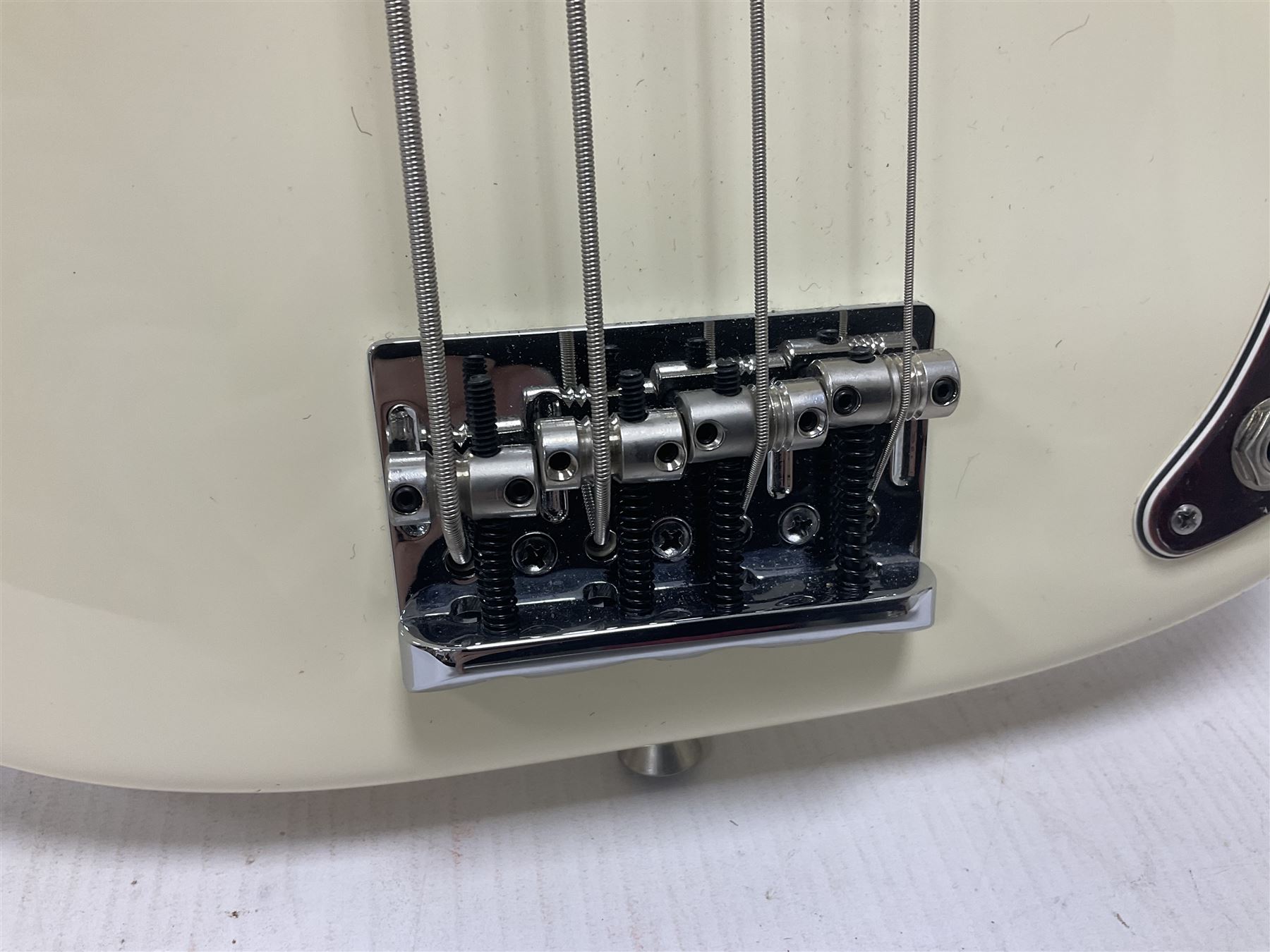 Fender Precision Bass guitar, in Olympic White finish with tortoiseshell effect scratchboard, serial no US15103092, in black Fender hard case with Fender strap and warranty card, guitar L116cm