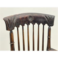 19th century elm and beech stick back armchair, the cresting rail carved with flower head and foliage, curved arms with scroll terminals, figured elm dished seat on turned supports joined by stretchers 
