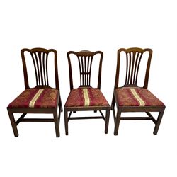 Set of six (5+1) George III mahogany dining chairs, shaped cresting rail over pierced and flared splat, drop-in seat upholstered in crimson and ivory floral patterned fabric, raised on chamfered square supports united by H-stretcher