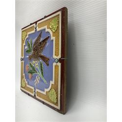 19th century Minton & Co majolica tile, decorated in relief with a bird upon a fruiting branch against a blue ground, with textured ochre border and anthemion to each corner, impressed mark verso, H19.7cm