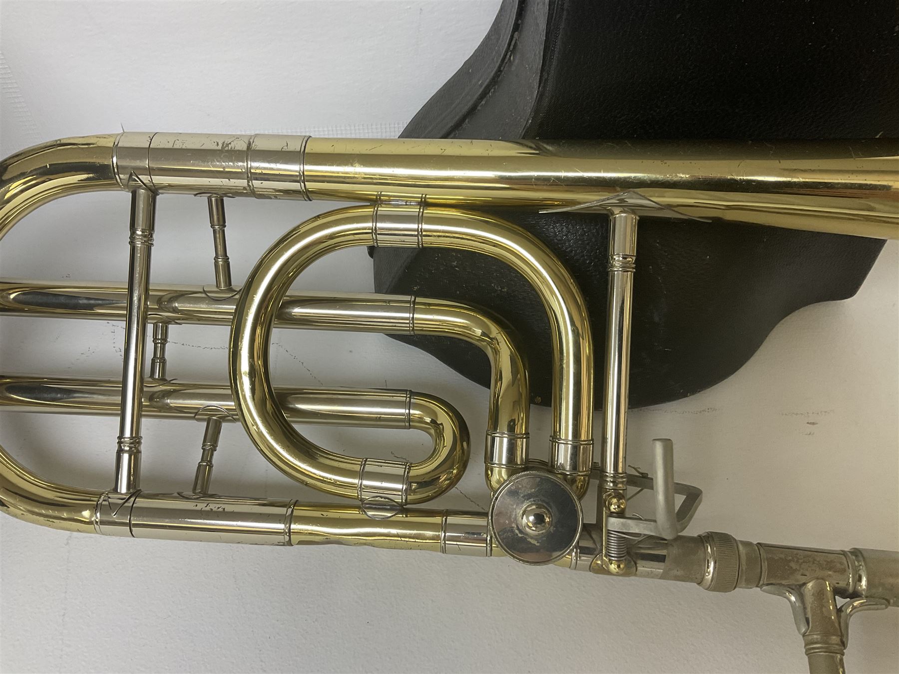 Three brass trombones comprising Elkhart Ind. USA 'CONN' model no.72H; Besson 'Concord'; and Selmer Distributed 'Lincoln'; two in carrying cases; and German B & M 'Champion' brass trumpet (4)