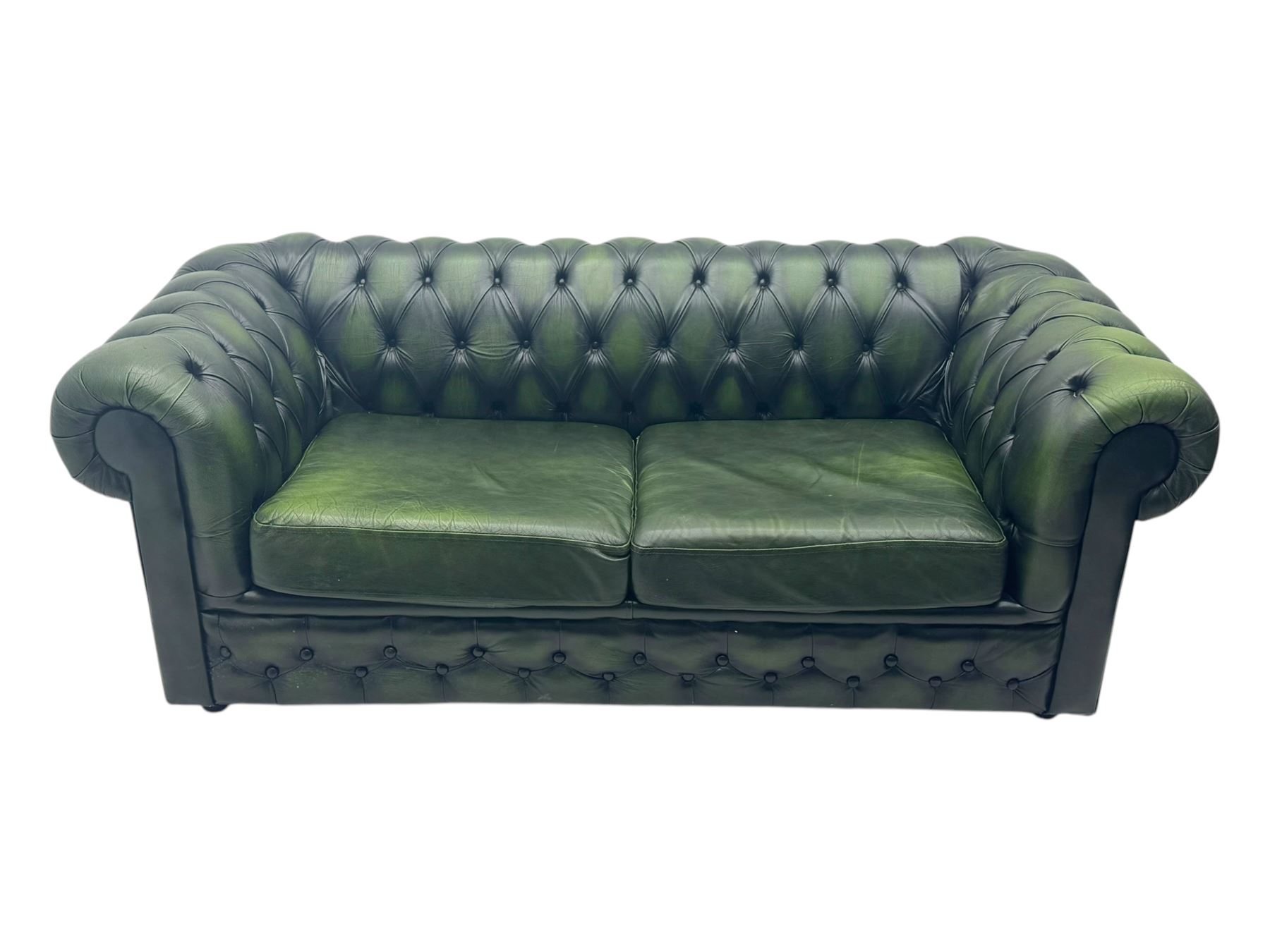 Two seat Chesterfield design sofa bed, upholstered in emerald green leather with deep-buttoned detailing, rolled arms, two loose seat cushions, and pull-out 