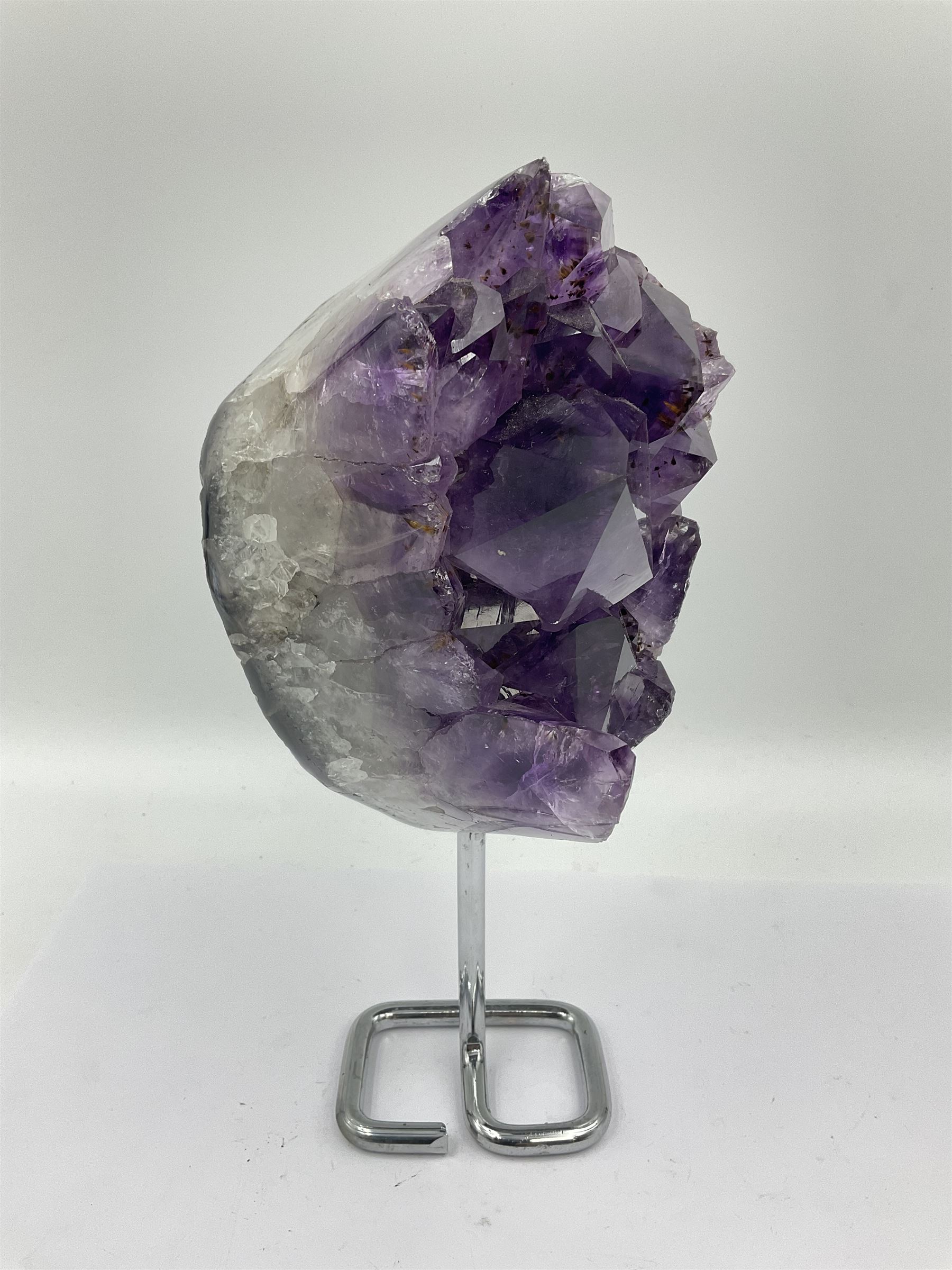Amethyst crystal geode cluster, with large well-defined crystals, upon a metal stand, H21cm