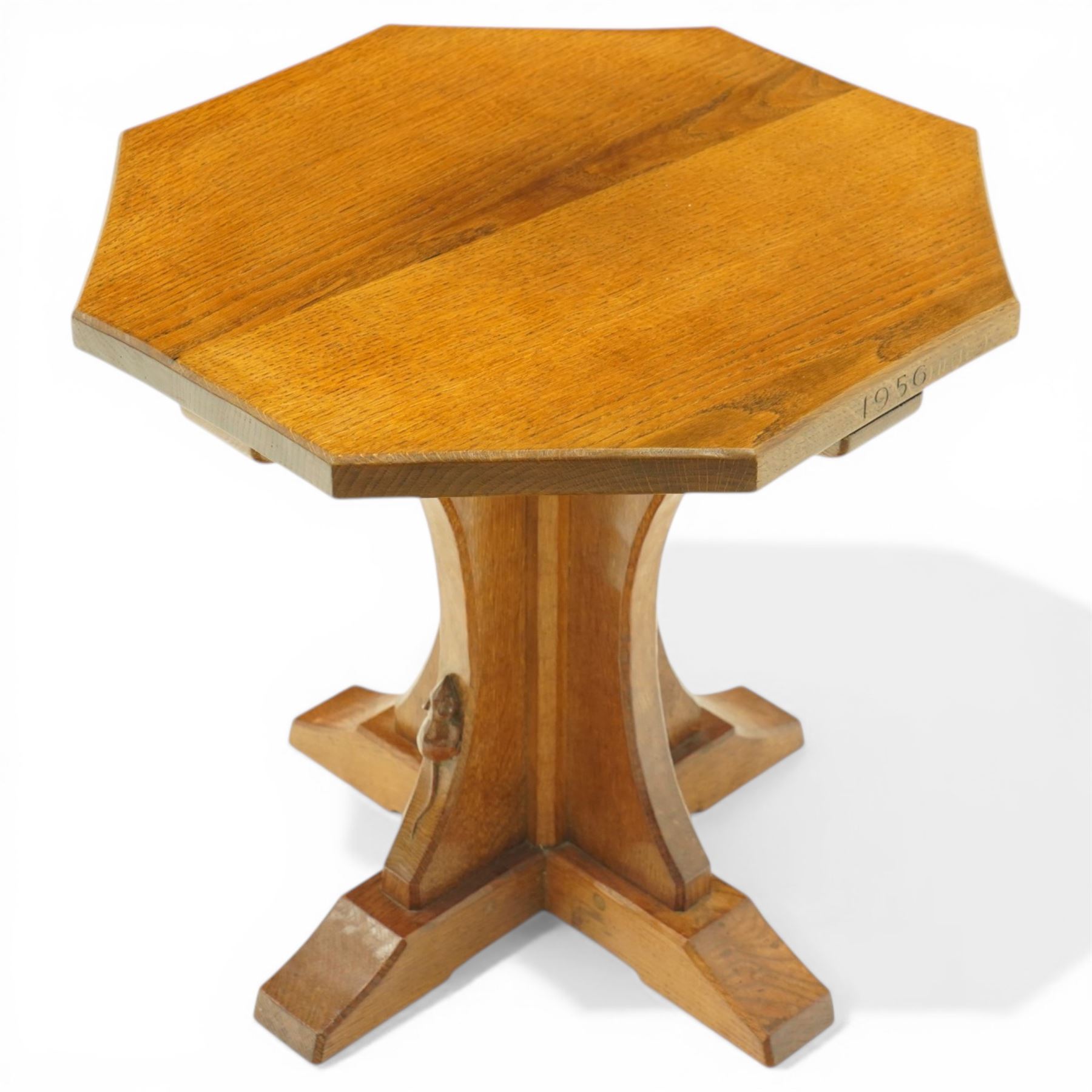 Mouseman - 1950s oak coffee table, octagonal adzed top on cruciform base and sledge feet, carved with mouse signature, dated 1956 and engraved 'Sylvia' to the top edge, by Ken Almack of the workshop of Robert Thompson, Kilburn

Notes:
Made by Ken Almack at the Robert Thompson workshop, Kilburn, where he trained and worked as a Mouseman craftsman; brother of Colin ‘Beaverman’ Almack, who later established his own workshop. The table was made for Sylvia to mark their engagement in 1956, prior to their marriage in 1957.

Provenance: The estate of Ken Almack; Tennants Auctioneers, 20th Century Design, 5 October 2024.