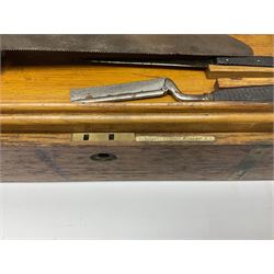 Naval doctor's surgical instruments, contained in a converted brass bound oak pistol box, the hinged lid opening to reveal two removable fitted trays, containing 19th century and later saws, scalpels, tweezers etc