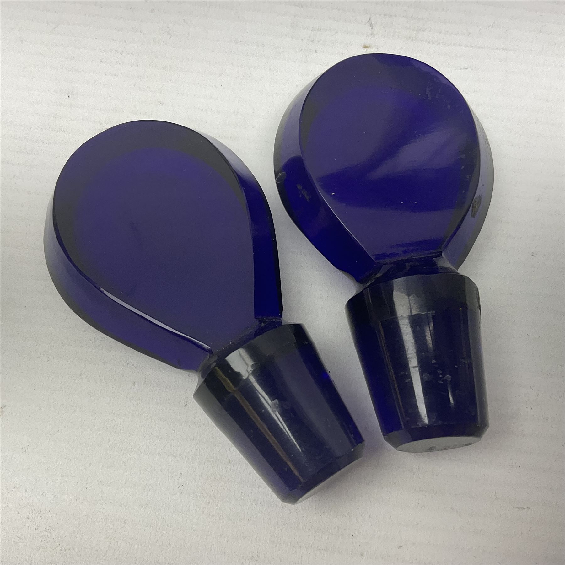 Pair of early 19th century blue glass decanters with teardrop stoppers, with gilt writing, the first marked Gin the second Brandy 