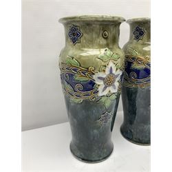Pair of Doulton Lambeth stoneware vases, of baluster form, with floral and foliate decoration upon a mottled blue/green ground, impressed mark and hd 8315 beneath, H34cm
