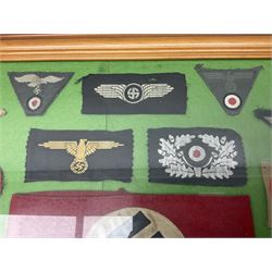 Framed display of thirty-four WWII German cloth badges including Luftwaffe pilot, Paratrooper, Afrikakorps cuff title, sleeve insignia for 'SS' Foreign Volunteers, various breast eagles including Luftwaffe, Army etc, RAD badges, Party Armband, rank and trade insignia, cap insignia etc; 40 x 50cm in modern pine frame