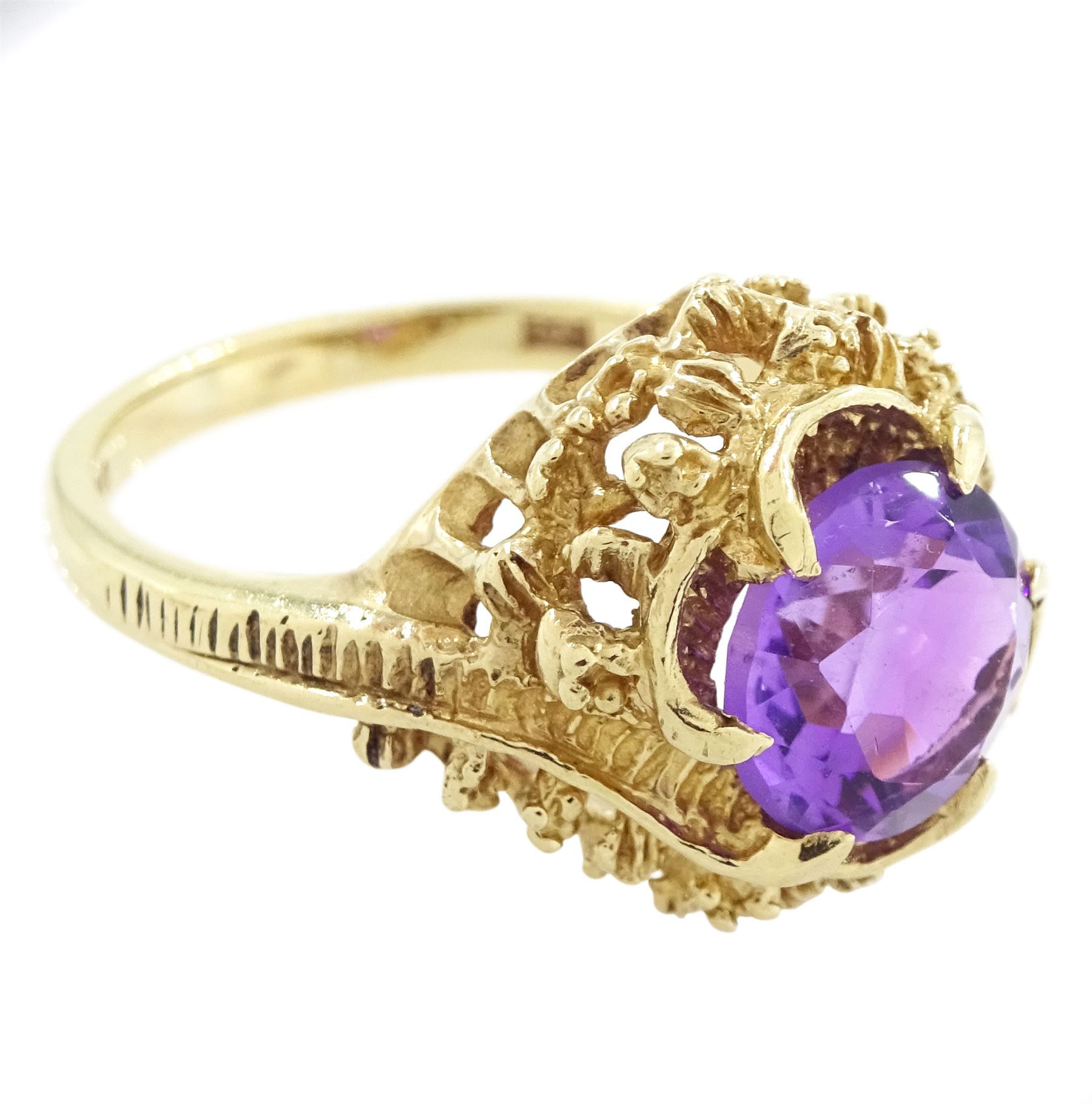 9ct gold amethyst single stone ring, round cut amethyst set within a pierced textured surround, London 1972