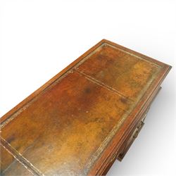 Late Victorian oak nine drawer desk, the rectangular top inset with a tooled leather writing surface bordered in gilt, above three frieze drawers and two pedestal cupboards each fitted with three graduated drawers, all with brass swan neck handles, raised on plinth bases