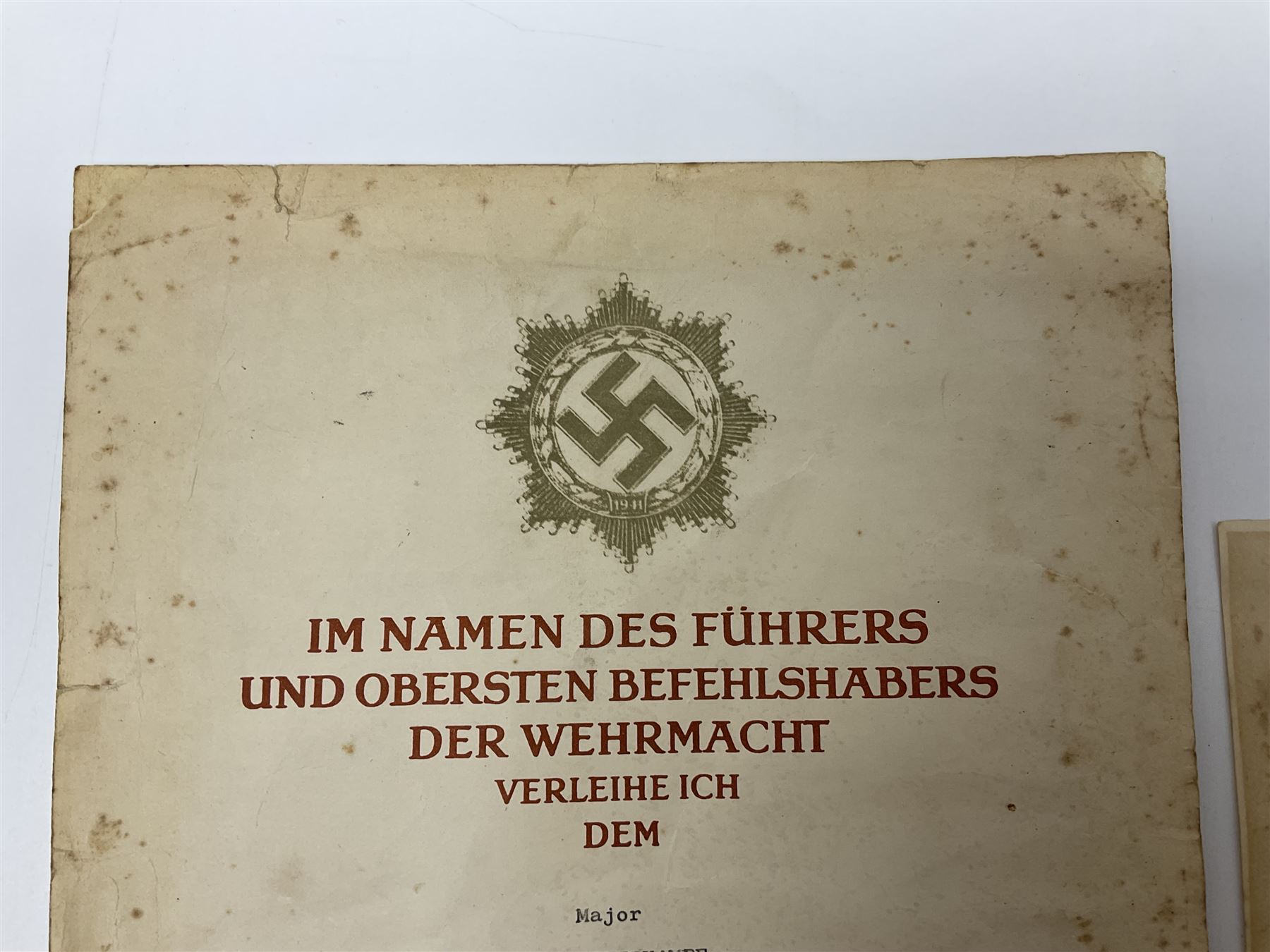 Three German documents dated 1942 - Gold Cross award to Major Ludwig Osterkampf; and Crete wound certificate and cuff title certificate awarded to Feldwebel Alfred Glaise; all unframed (3)