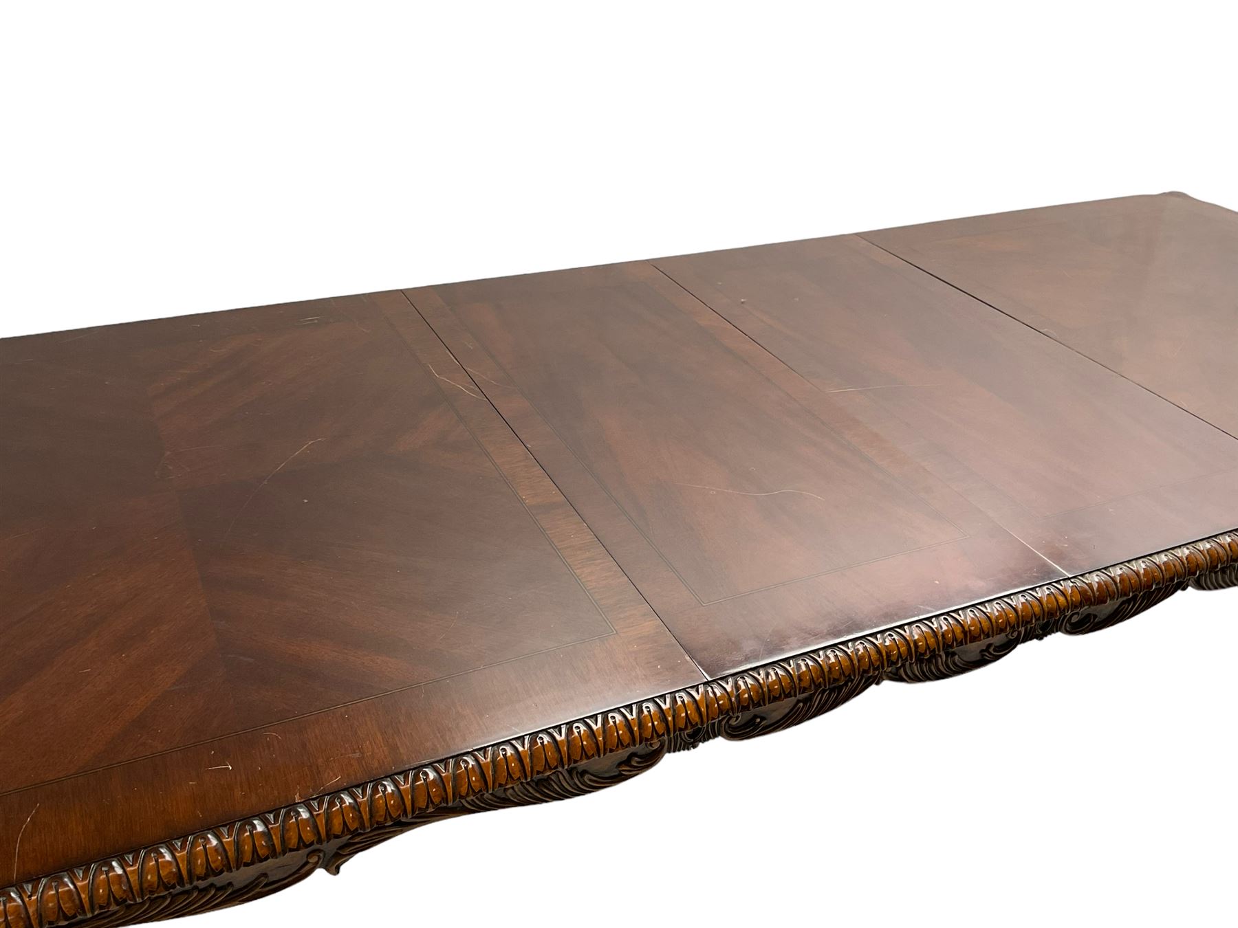 Chippendale Revival - hardwood extending dining table, rectangular gadroon carved top, on acanthus carved cabriole supports with ball and claw feet, with two additional leaves; together with a set of eight (6+2) dining chairs, shaped cresting rail over pierced and carved splat, upholstered drop-in seat, on acanthus carved cabriole supports with ball and claw feet