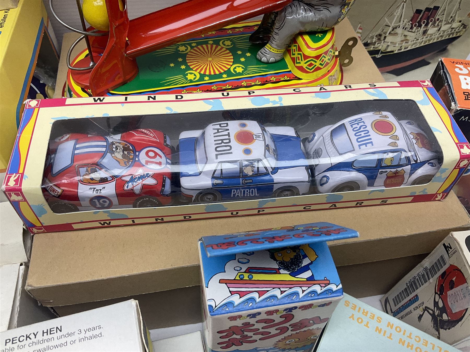 Twenty six tinplate models to include Ferris Wheel and Performing Circus Elephant, marked JW, further similar examples such as Duck on a Bike, Clown on Roller, Carousel; Popeye Tin Speedboat; Looney Tunes Wind Up Cars and Express Train; various international examples, MS107 Jumping Bambi, Pop Pop Boat, jumping frogs, pecking chickens etc; both boxed and loose