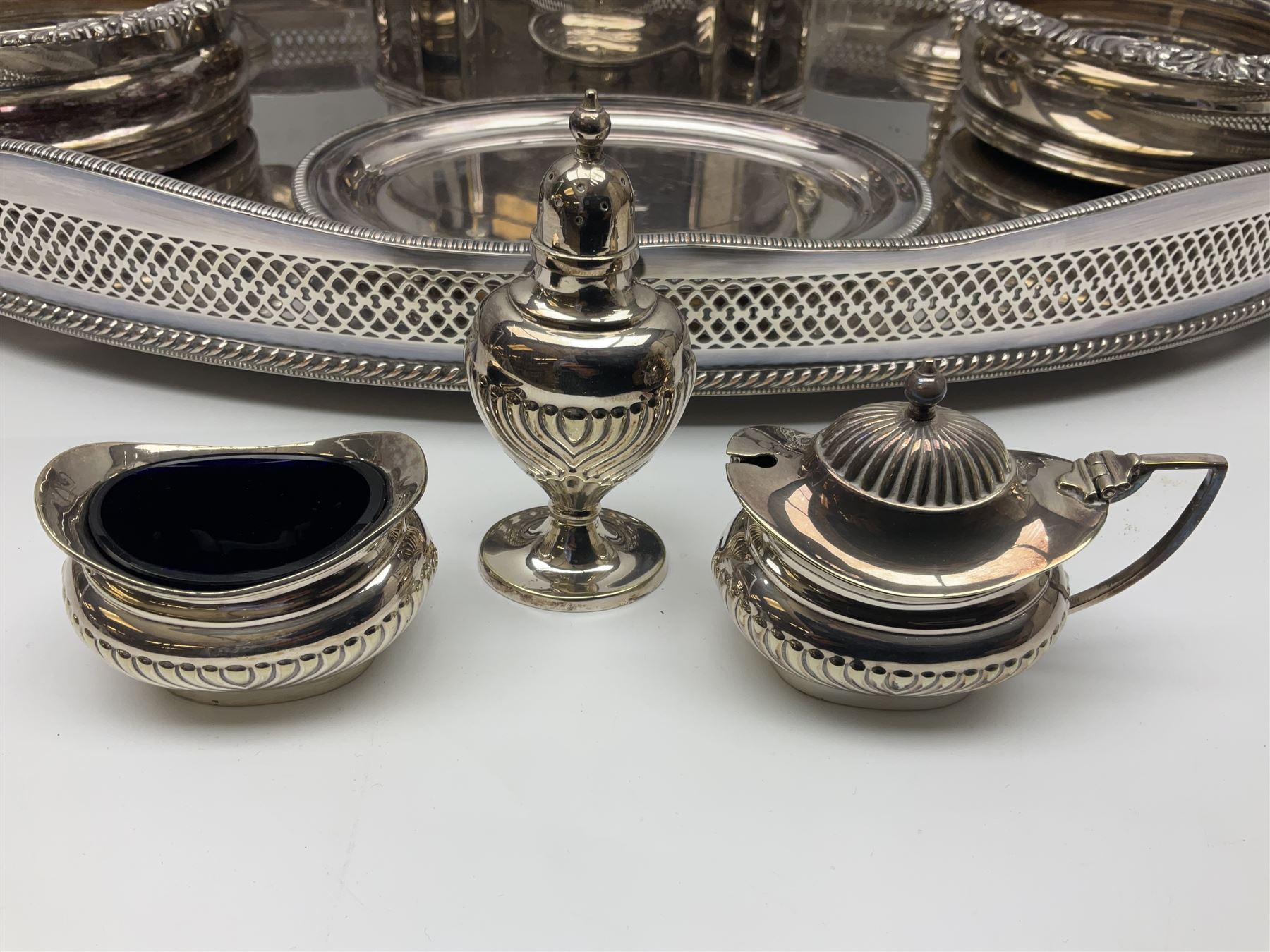 Pair of Mappin and Webb silver plate pierced pedestal bon bon dishes, together with other silver plate comprising teapot stand engraved with lion's head to centre, two cut glass claret jugs, two bottle coasters with acorn decoration, two open salts upon dolphin mounts, tea caddy, three piece cruet set and a large oval tray with pierced sides and upon four ball feet