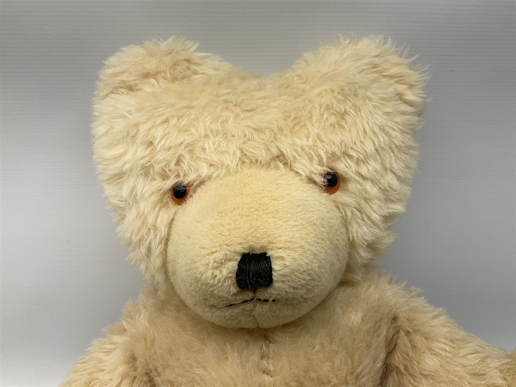 Mid-20th century English plush covered woodwool filled dog with vertically stitched nose and mouth L39cm; and Wendy Boston plush covered teddy bear, the fixed head with applied eyes and vertically stitched nose and mouth H63cm (2)