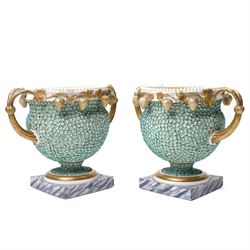 Pair of 19th century Grainger Lee & Co Worcester urns, c1820s-1830s, hand-painted with views of 'Near London Bridge' and 'Brighton Pavilion' upon a ground of encrusted forget-me-not decoration, the beaded rim with twin naturalistically formed handles, leading into vines moulded with strawberries in high relief, the pedestal painted to imitate marble, painted marks to base, H20cm