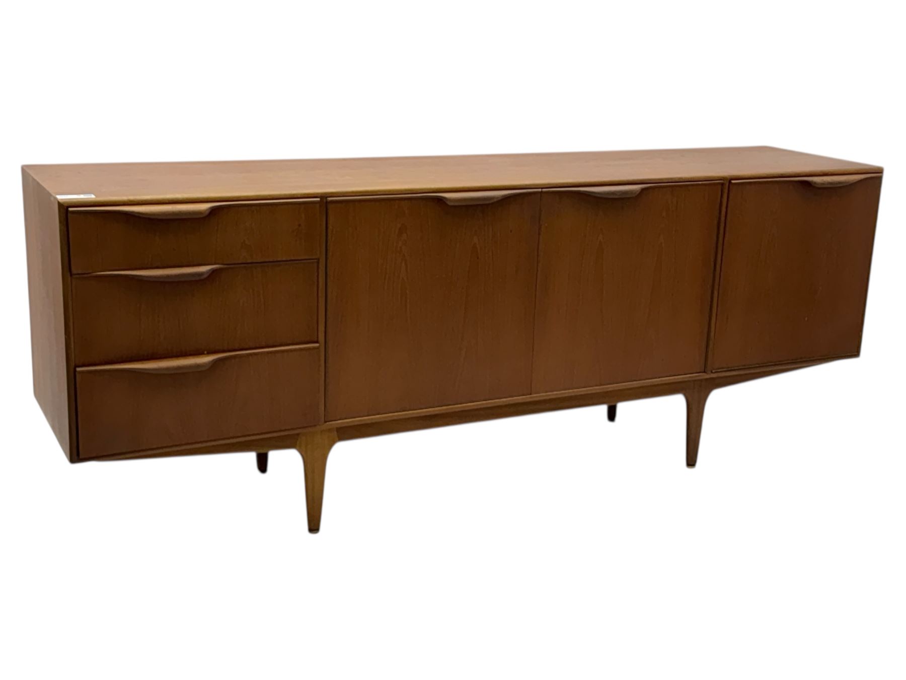 Tom Robertson for AH McIntosh & Co of Kirkaldy - mid-20th century teak 'Dunvegan' sideboard, with three graduating drawers fitted cutlery divider, three cupboards one fall front each with recessed sculptural handles, raised on shaped and tapering supports