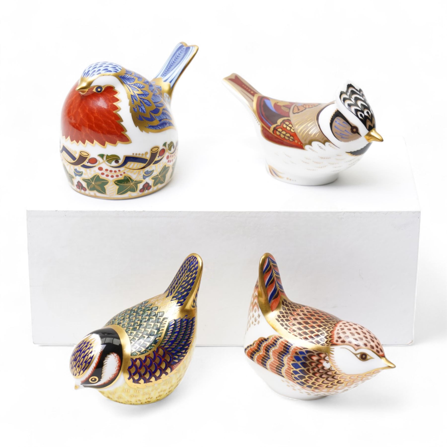 Four Royal Crown Derby paperweights, comprising crested Tit with original box and gold stopper, Robin with silver stopper, Blue Tit with gold stopper, and Jenny Wren (4)