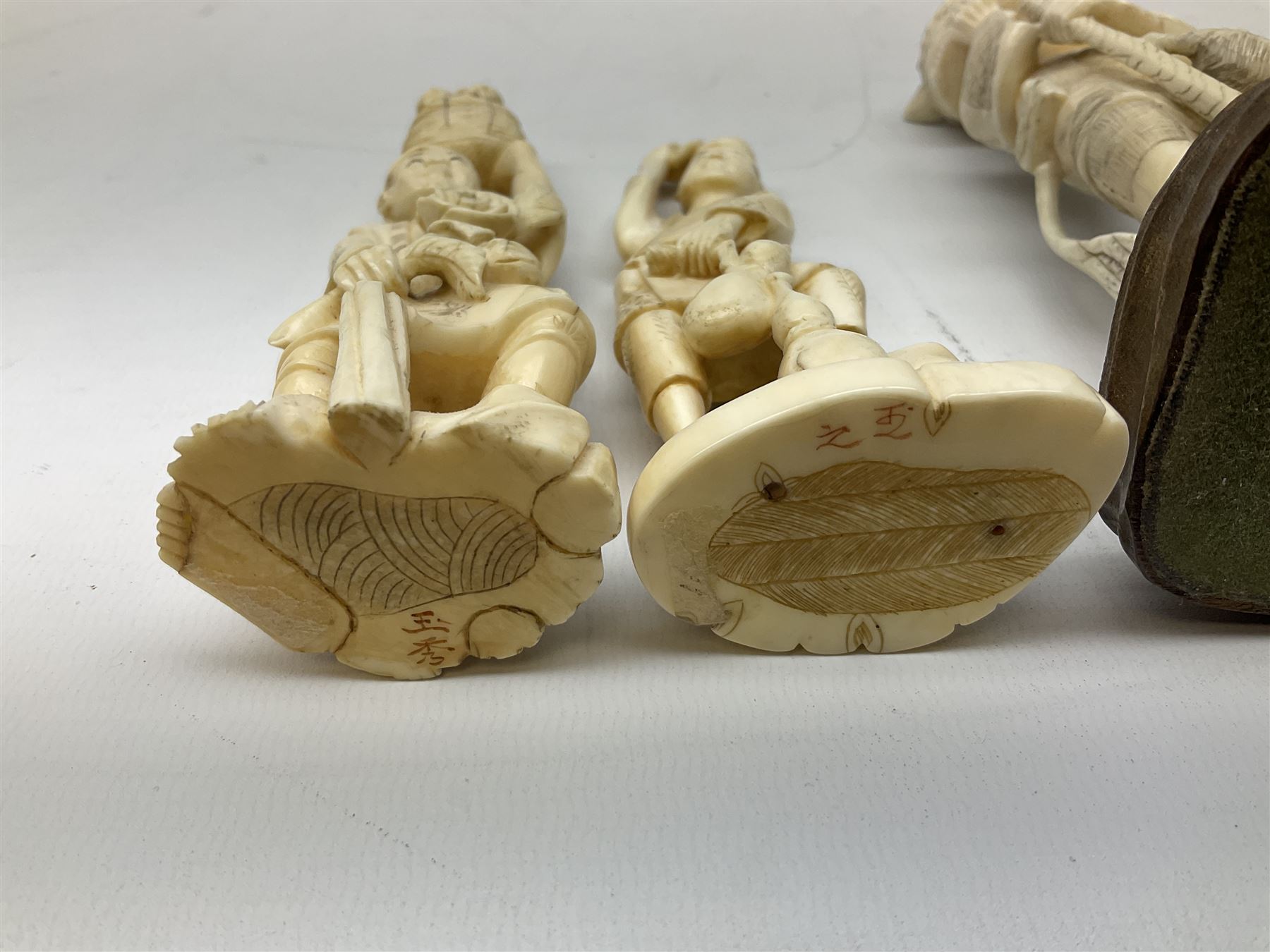 Three Japanese Tokyo School ivory figure, 19th century, comprising of man standing holding double gordes, man holding a flower with a basket on his head and a man with an adze and a basket with a frog in, tallest example H19cm, 
