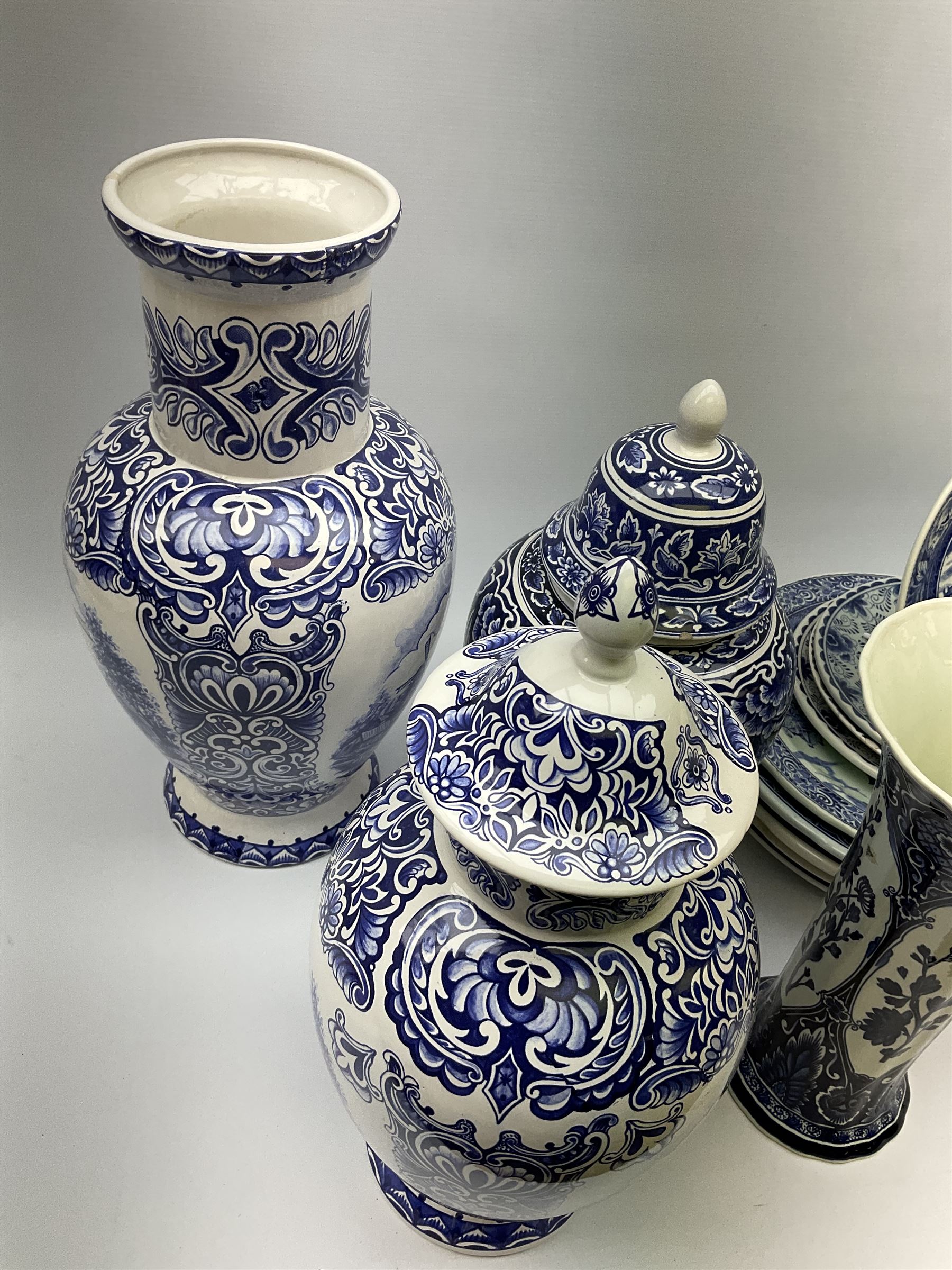 A large collection of modern transfer printed Delft ware, to include large baluster vase, H42cm, two jars and covers, largest H40cm, pair of tapering cylindrical vases, H31cm, and a number of plates of various size and design. 