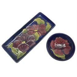 Moorcroft rectangular pin dish decorated in the Clematis pattern upon cobalt blue ground, together with a small circular footed dish decorated in the Hibiscus pattern, both with impressed marks beneath, tray L20cm (2)