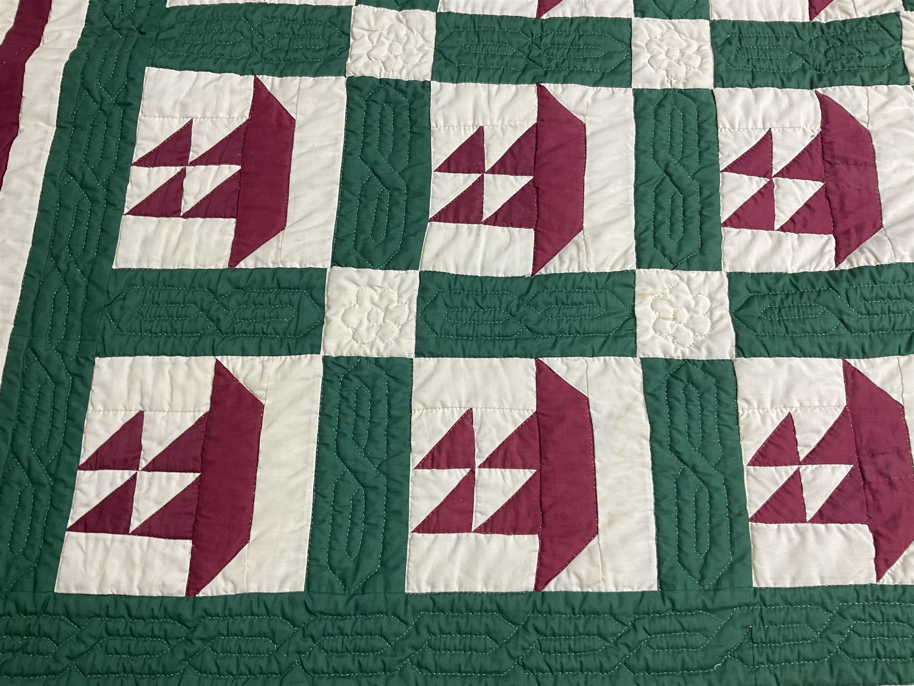 20th century quilt, with repetitive ship design to the centre within a cream red and green boarder, 227cm x 222cm