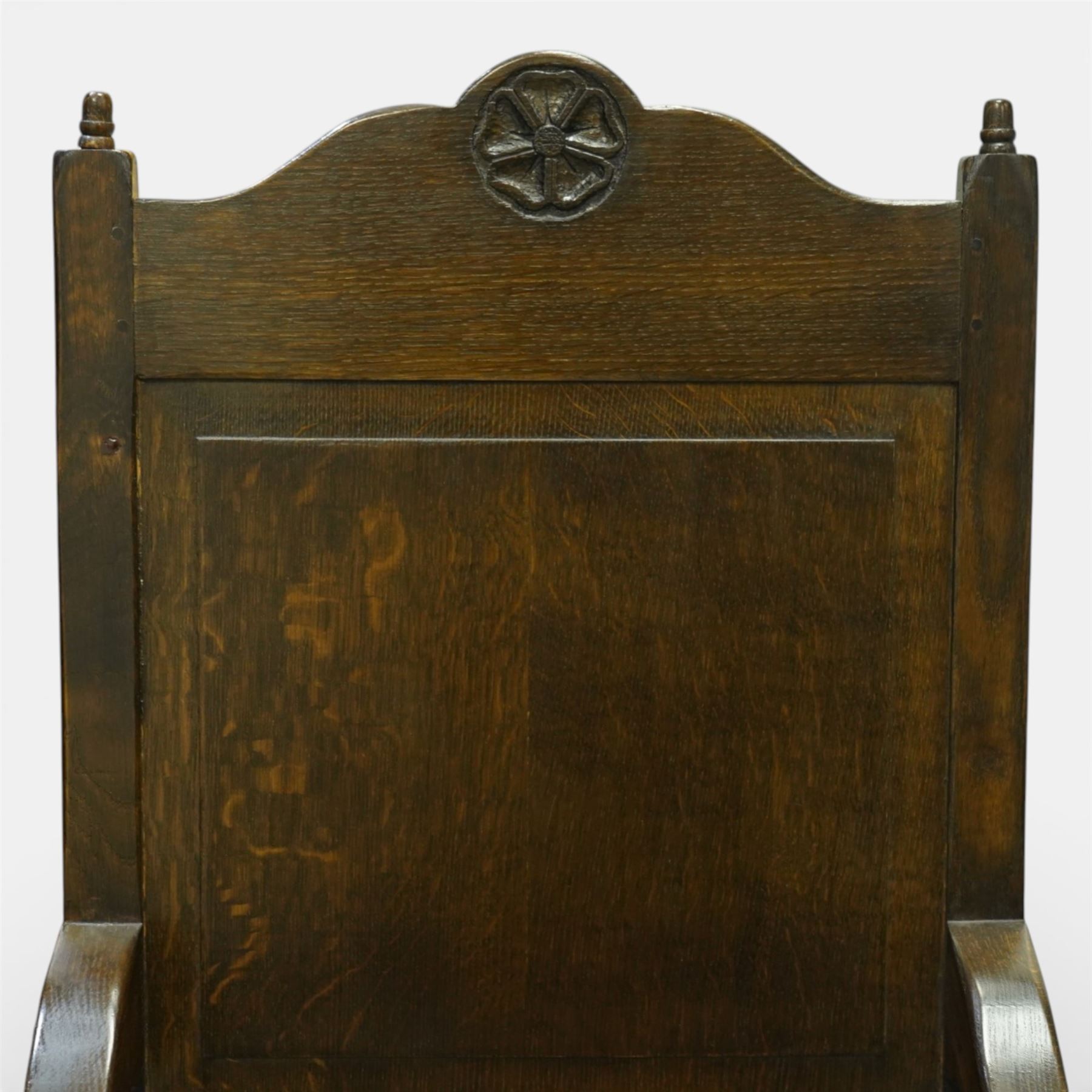 20th century oak refectory style dining table and eight chairs (6 + 2), rectangular top on two large carved baluster pedestal supports with leaf decoration, on splayed trestle bases joined by a stretcher, with eight matching oak dining chairs, each with Yorkshire rose carved cresting rail, panel back and solid seat, raised on turned supports united by stretchers