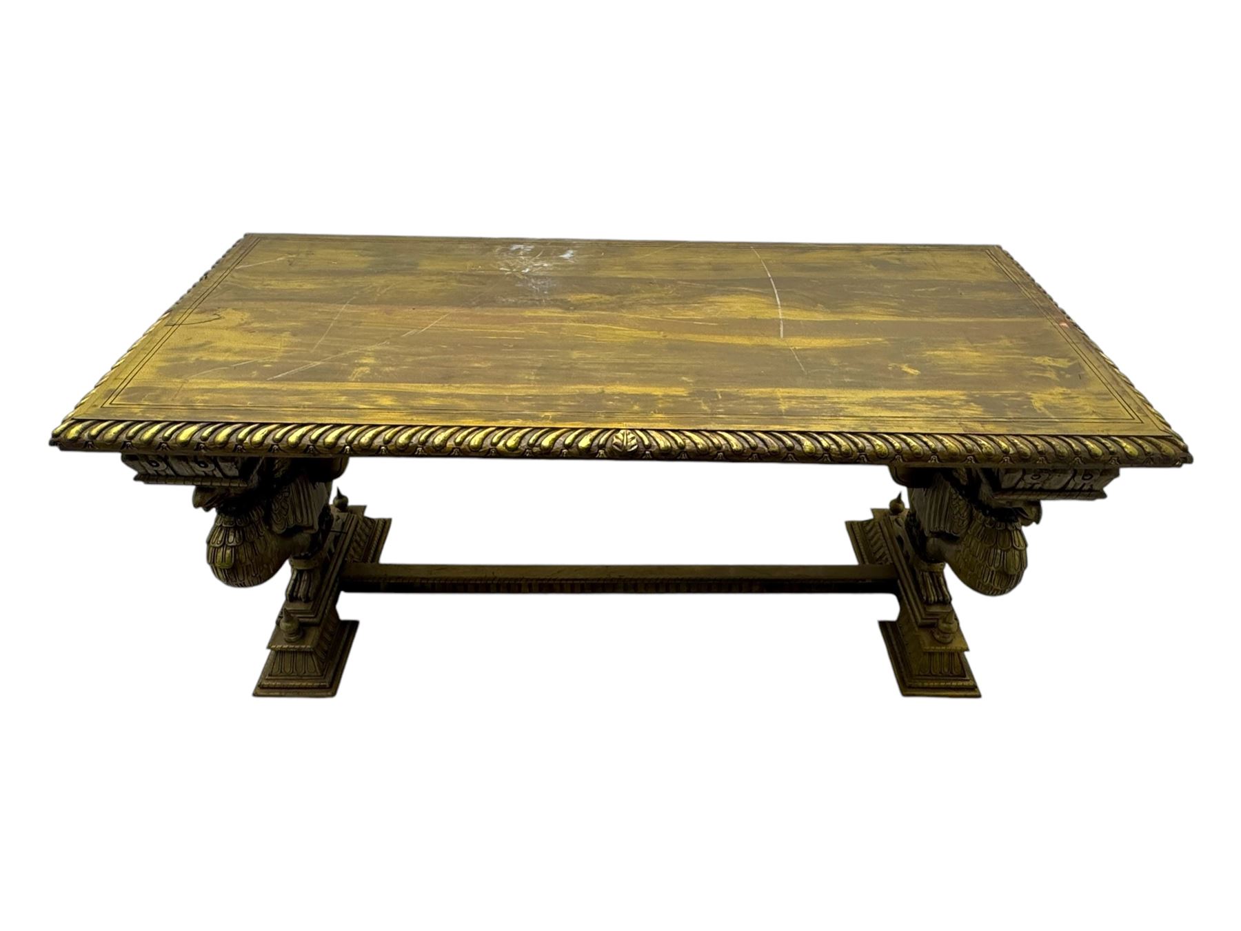 19th century Renaissance Revival carved and giltwood centre table, the rectangular top with gadrooned edge and carved frieze of repeating arched motifs with stylised scrolls, supported by a pair of carved winged griffin supports restrained by a central chained figure, on stepped rectangular bases united by carved stretcher