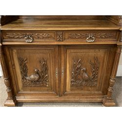 Late 19th century oak buffet cabinet, projecting moulded cornice above raised glazed cabinet with acanthus leaf and vertical fluted frieze supported by two turned columns, panelled back and moulded rectangular canted top, two drawers above cupboard enclosed by fielded panelled doors mounted with carved duck and pheasant figures in naturalist settings, flanked by two turned and fluted pilasters, moulded base with turned squat bun feet