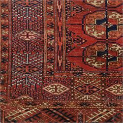 Central Asian Turkmen Tekke hand-knotted rug, madder red field decorated with rows of octagonal guls linked by secondary motifs within a dense geometric border, with fringe ends  
