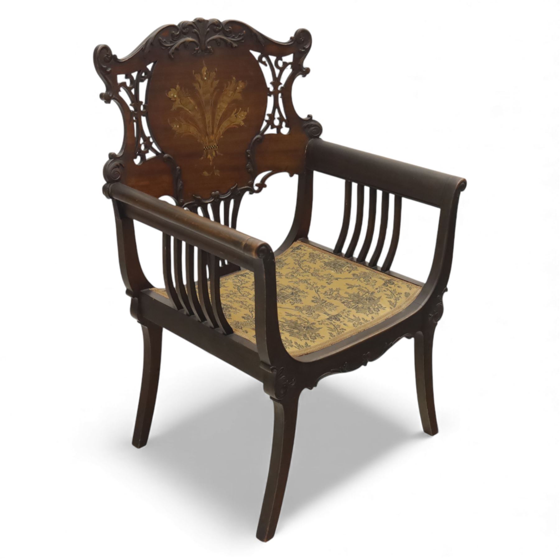 Art Nouveau mahogany open armchair in the manner of Shapland & Petter, the shaped and pierced back with foliate cresting and central panel inlaid with stylised marquetry plume, curved arms over upholstered seat, raised on sabre legs