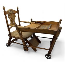 Late 19th century American oak child's metamorphic high chair and play table, carved spindle backrest with pierced splat, detachable tray with abacus and hand painted pastoral decoration, on turned supports with metal wheels