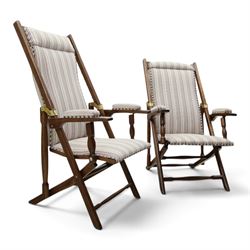 Pair of early 20th century oak framed garden reclining and folding deckchairs, high back and seat upholstered in striped fabric with padded armrests