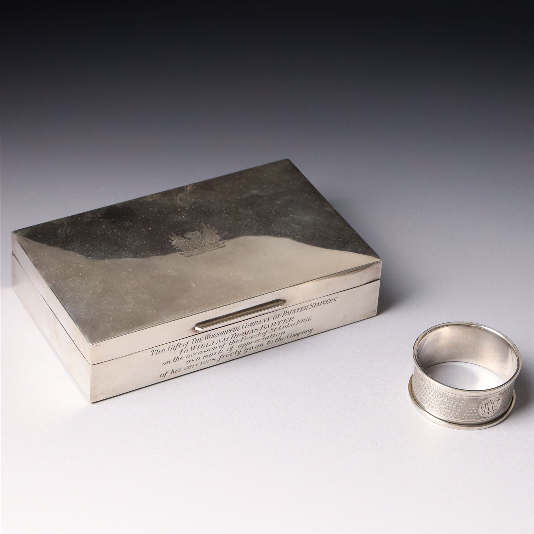 Silver cigarette box with presentation inscription, the hinged cover engraved with the crest of The Worshipful Company of Painter-Stainers W14cm London 1965 Maker Cohen & Charles and a silver napkin ring
