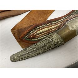 Saudi Arabian khanjar dagger with 29.5cm curving double edged  steel blade; white metal and copper mounted horn grip; in white metal mounted brass and leather scabbard incorporating embroidered leather wearing strap