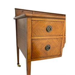 Edwardian satinwood knee-hole writing table or desk, raised back over blue leather inset, fitted with five drawers, each with quarter-veneered fronts, shaped corner brackets, on square tapering supports with brass cups and castors