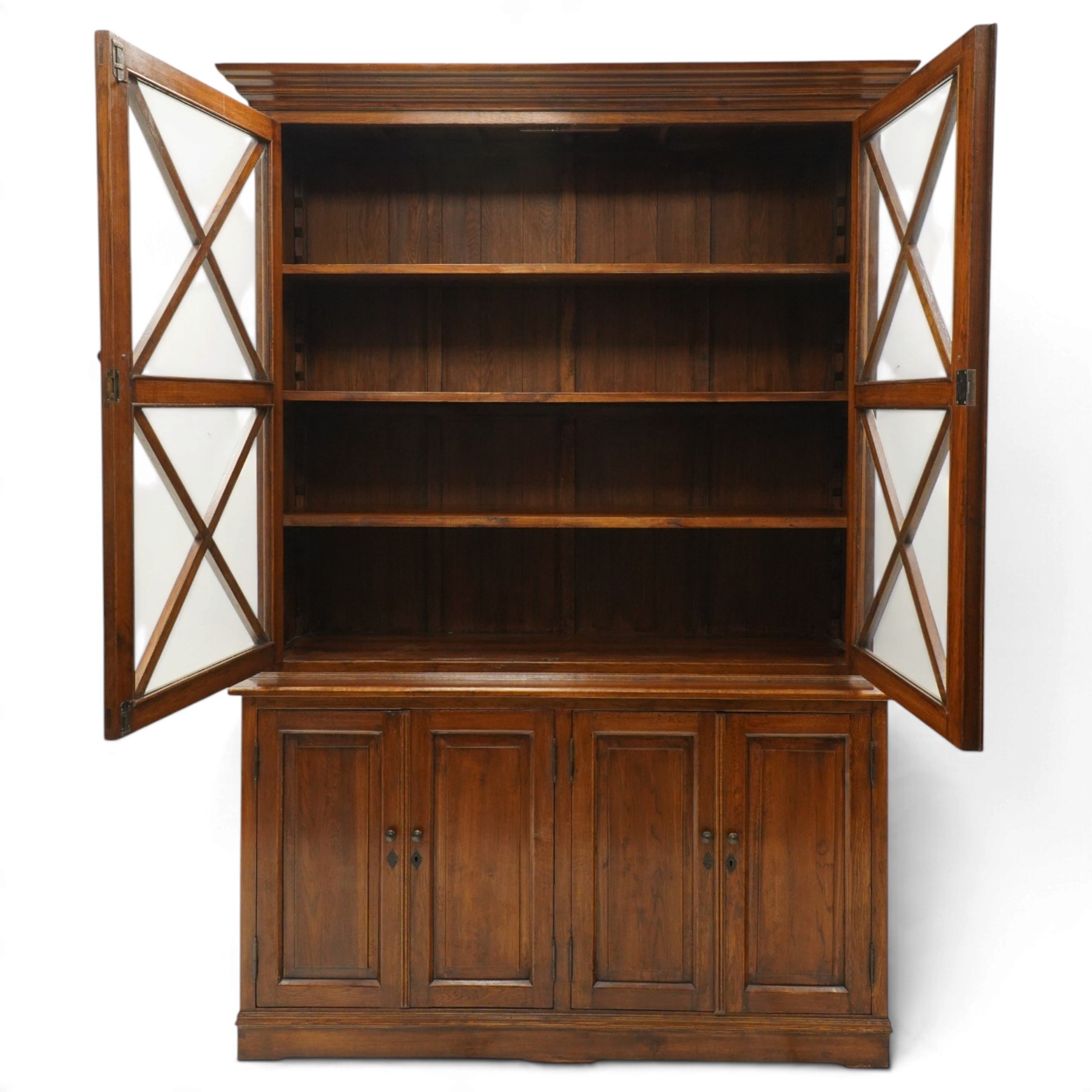 OKA - Glazed bookcase dark oark cabinet, the top with projecting cornice above astragal style glazed doors metal turned knobs, enclosing adjustable full length shelving, the lower half with two sets of twin cabinet doors housing fixed shelving, raised on a moulded plinth base  