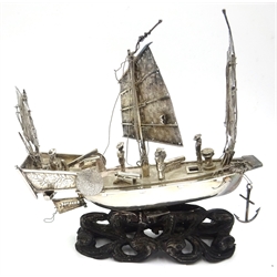  Early 20th century Chinese silver model of a dragon boat, with rowers and musicians, marked, 15.5cm long, similar gun boat 11cm and a rowing boat 13cm all on carved hardwood stands, two bearing character signatures  