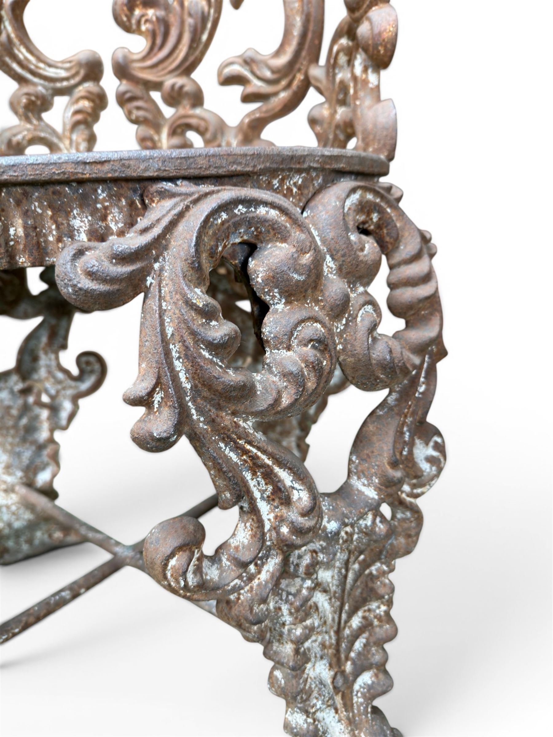 19th century Rococo Revival cast iron garden chair, pierced back comprised of scrolling acanthus leaves, over a pierced geometric white painted drop-in seat, raised on four acanthus and anthemion shaped cabriole supports united by X-frame stretcher