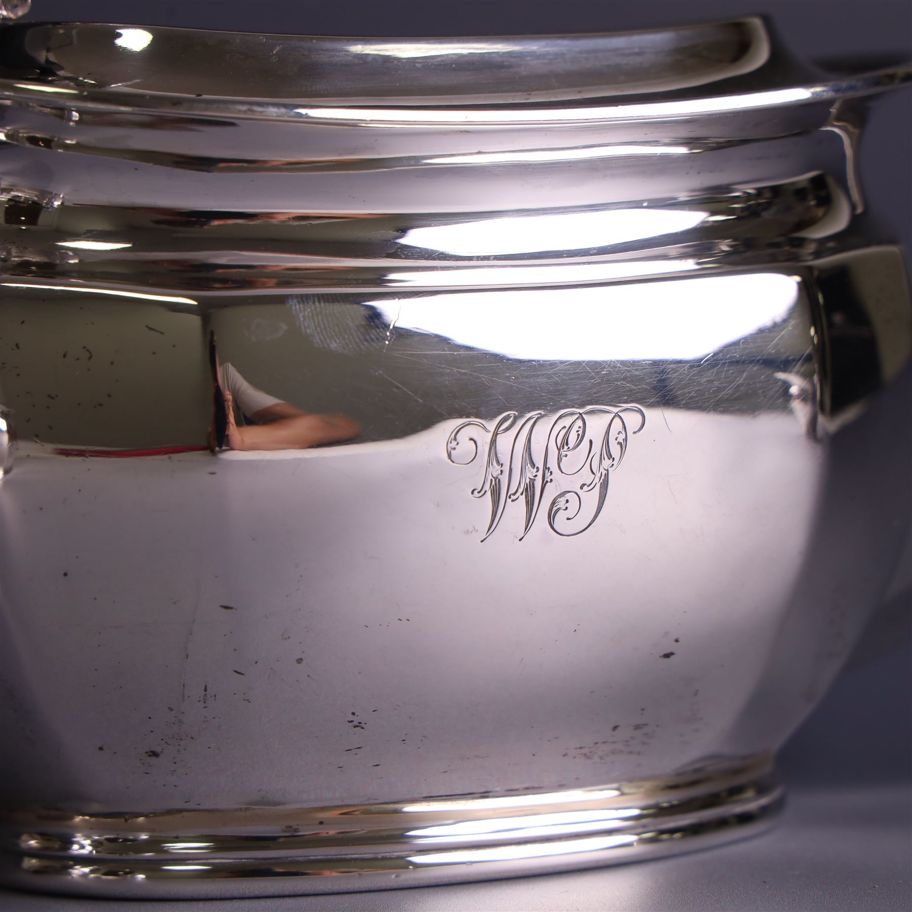 1930s silver four piece tea service, comprising teapot, hot water pot, sugar bowl and milk jug, each of part faceted oval form with engraved monogram to body, the teapot and hot water pot with Bakelite type handles and finials, hallmarked Atkin Brothers, Sheffield 1933