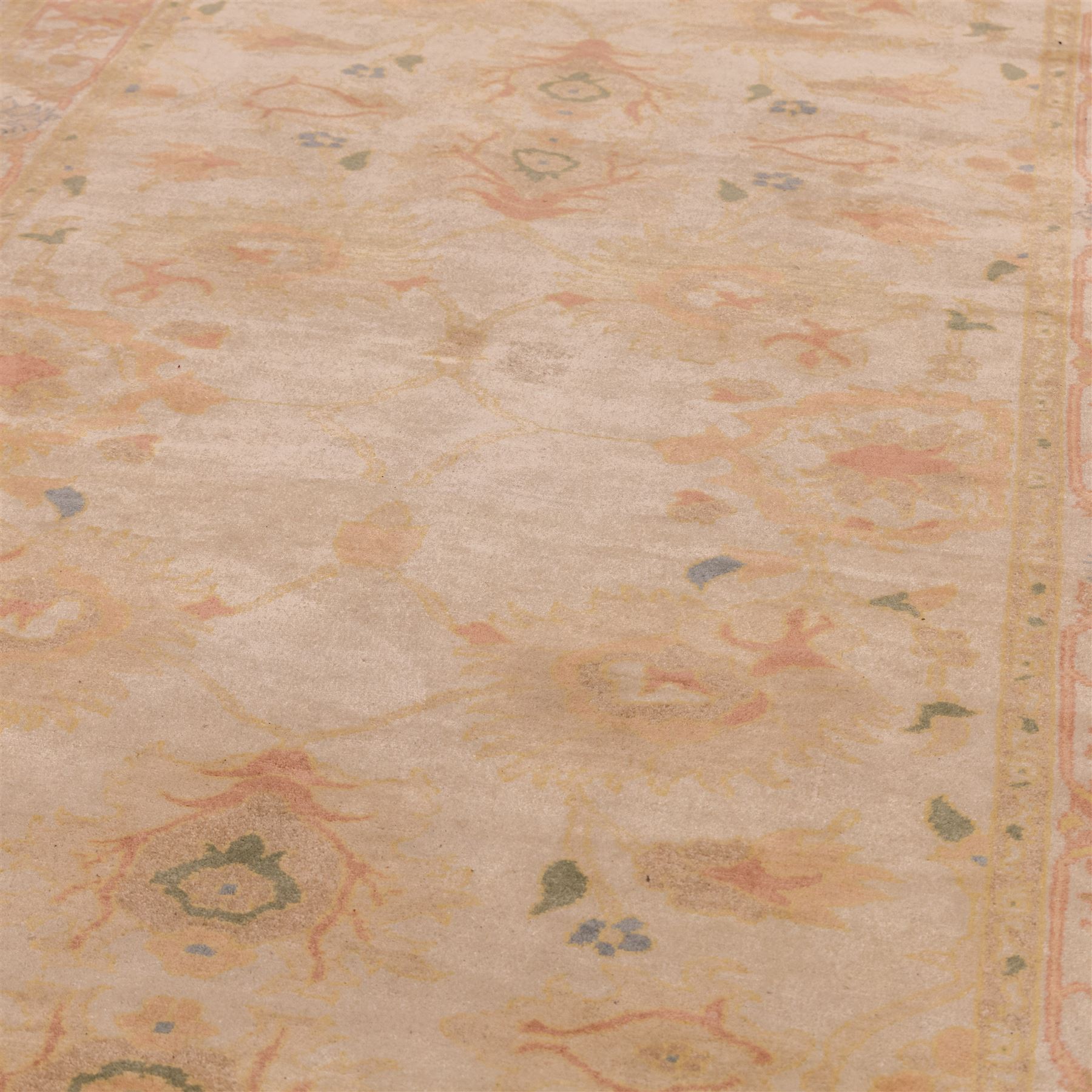 West Persian hand-knotted Ziegler design rug, ivory field decorated with an all-over lattice of stylized palmettes and floral sprays linked by angular vines, border of scrolling floral ornamentation in a palette of blush pink, sage green, powder blue, and soft ochre, with cotton fringe ends 